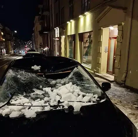 Snø og is på en parkert bil i en bygate